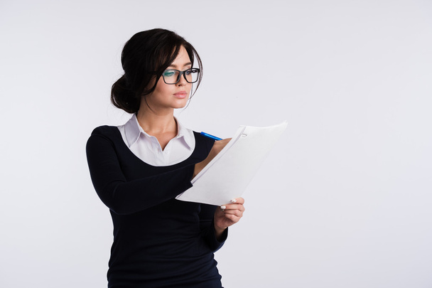 Thoughtful woman with papers standing isolated on a white background - Photo, image