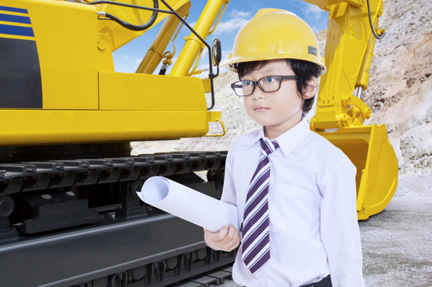 Little Architect with blueprint and excavator - Foto, imagen