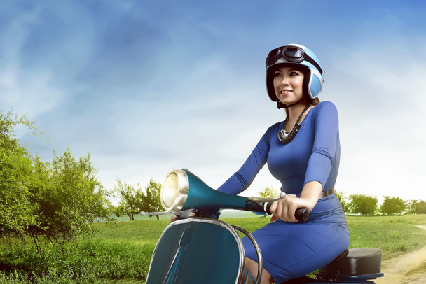 woman riding scooter on countryside road - Photo, Image