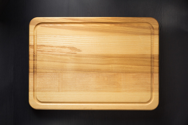 cutting board at wooden table  - Foto, afbeelding
