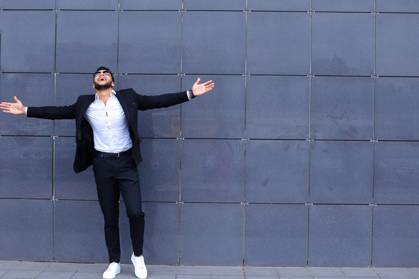 Арабська хлопець у бізнес-центрі стоїть, посміхаючись, ходьба повільно - Фото, зображення