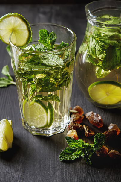 Mint iced tea with lime in the glass. Dark background. - Фото, изображение