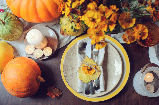 Осенний традиционный сезонный стол с тыквами, свечами и цветами
 - Фото, изображение