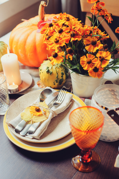 autumn traditional seasonal table setting at home with pumpkins, candles and flowers - 写真・画像