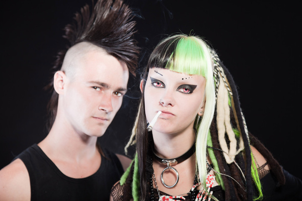 Couple of cyber punk girl with green blond hair and punk man with mohawk haircut. Isolated on black background. Studio shot. - Photo, Image