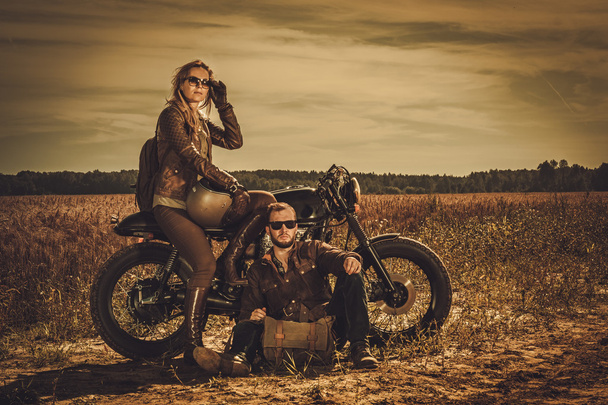 Coureur de café élégant couple sur les motos personnalisées vintage dans un domaine
. - Photo, image