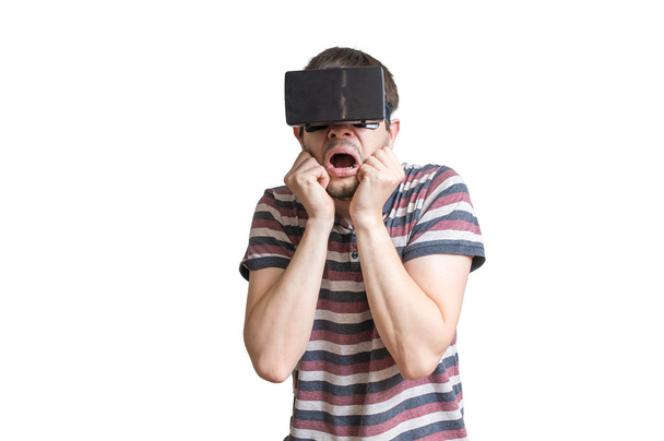 Człowiek nosi 3d zestaw wirtualnej rzeczywistości i jest przerażony czegoś. Na białym tle. - Zdjęcie, obraz