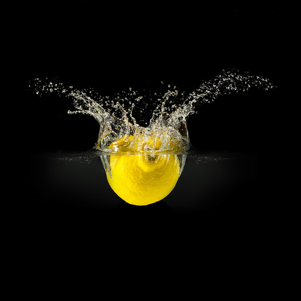 Fresh fruits falling in water with splash on black background - Foto, Bild