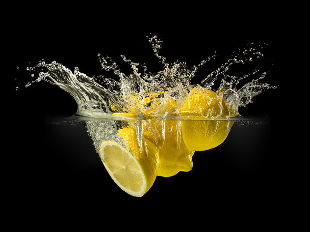 Group of fresh fruits falling in water with splash on black background - Photo, image