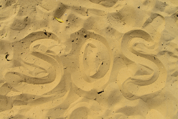 inscription SOS in the sand on the beach - Foto, Bild