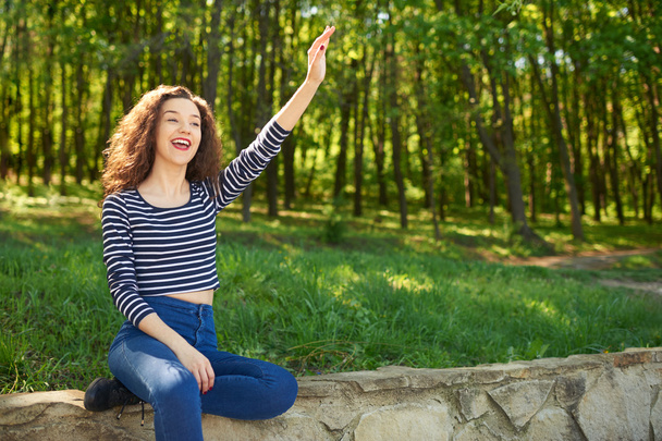 Beautiful young woman waves hand to somebody - Photo, Image