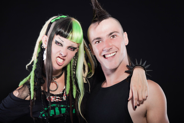 Couple of cyber punk girl with green blond hair and punk man with mohawk haircut. Expressive faces. Isolated on black background. Studio shot. - Photo, Image