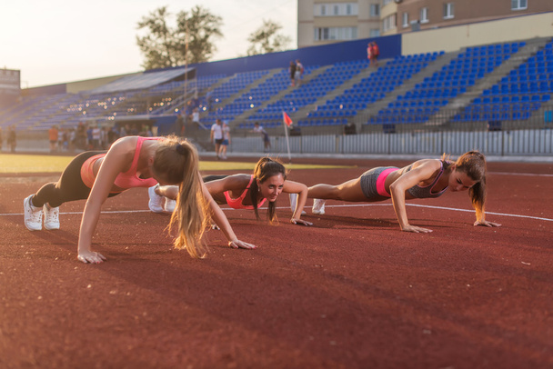 фитнес-женщины, тренирующиеся на стадионе
 - Фото, изображение