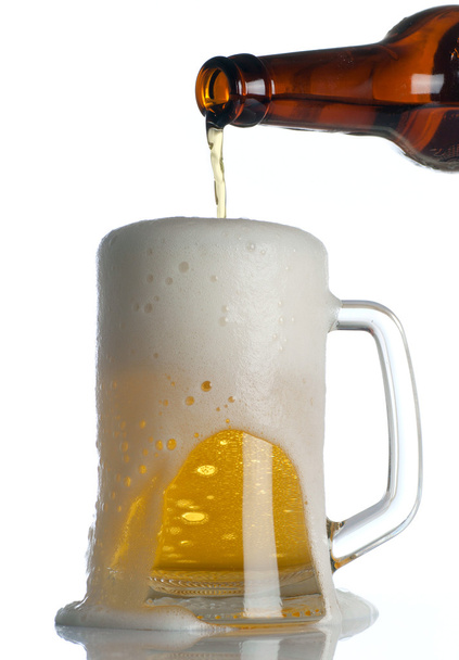 Beer is Pouring into mug on white - Foto, afbeelding