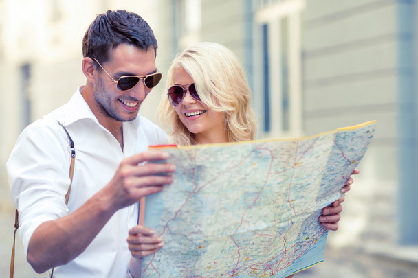 smiling couple in sunglasses with map in the city - Photo, Image