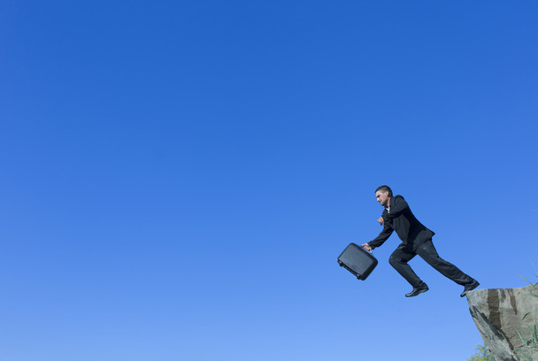 Jumping man met een diplomaat uit een klif. - Foto, afbeelding