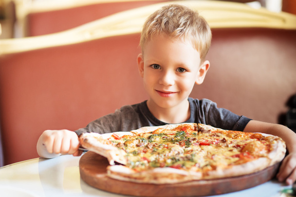 Roztomilý chlapeček, jíst pizzu v restauraci - Fotografie, Obrázek