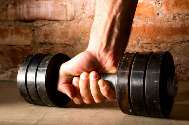Male hand is holding metal barbell - Foto, Imagen