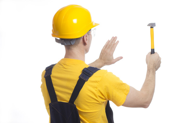 Εργαζόμενος σε ένα κράνος και ένα κίτρινο μπλουζάκι - Φωτογραφία, εικόνα
