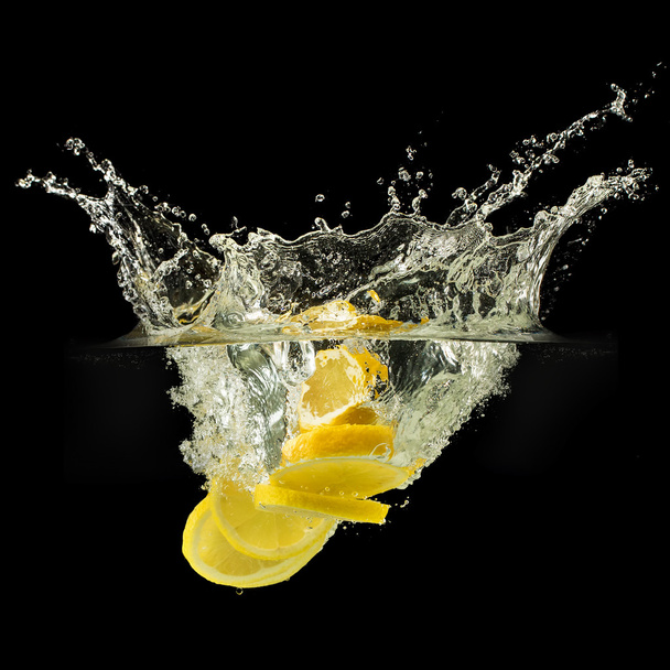 Group of fresh fruits falling in water with splash on black background - 写真・画像