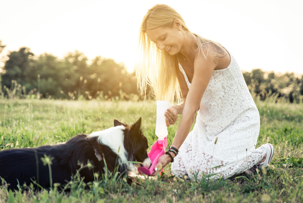 Blonde woman playing with border collie - Фото, изображение