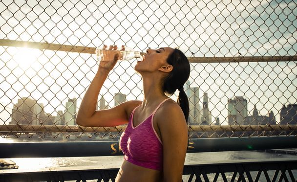 Female runner drinking water after run - Zdjęcie, obraz