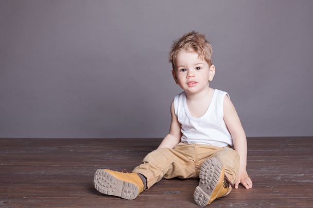 little boy sitting on wooden floor - Фото, зображення
