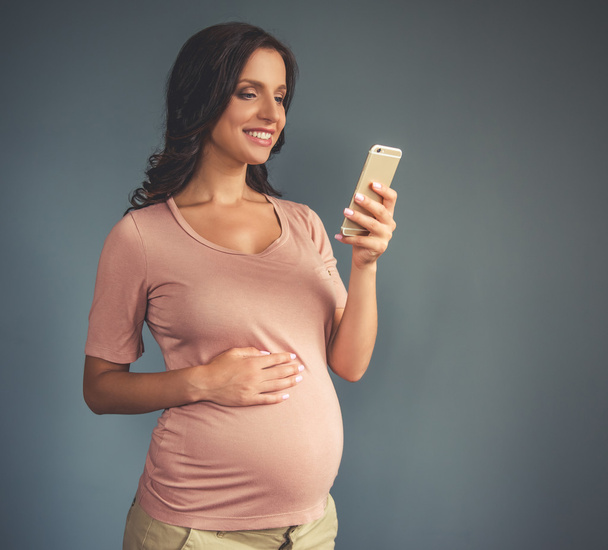 Beautiful pregnant woman with gadget - Foto, Imagem