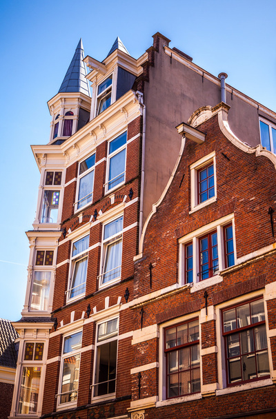 AMSTERDAM, NETHERLANDS - AUGUST 15, 2016: Famous buildings of Amsterdam city centre close-up. General landscape view of city streets and traditional Dutch architecture. Amsterdam - Netherlands. - Foto, imagen