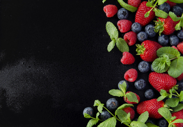 fresh strawberries, raspberries and blueberries on a black background - Photo, Image