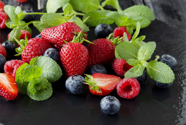 fresh strawberries, raspberries and blueberries on a black background - Photo, Image