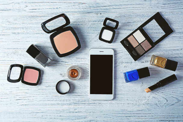 Decorative cosmetics and smartphone on wooden background - Foto, immagini