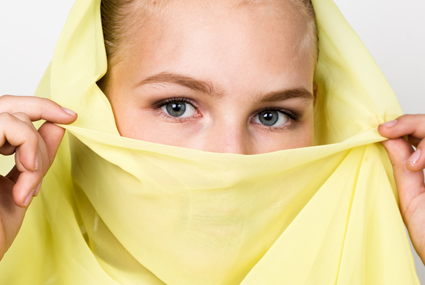 close-up beautiful mysterious eyes eastern woman wearing a yellow hijab - Foto, imagen