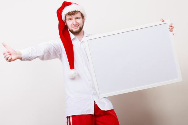 Man in santa hat with blank banner. Copy space. - Photo, image