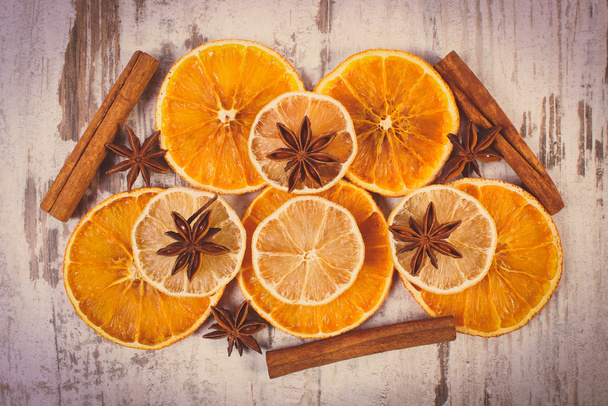 Vintage photo, Slices of dried lemon, orange and spices on old wooden background - Fotoğraf, Görsel