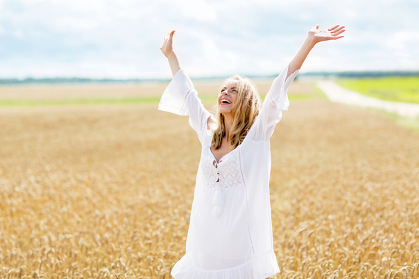 smiling young woman in white dress on cereal field - Fotoğraf, Görsel