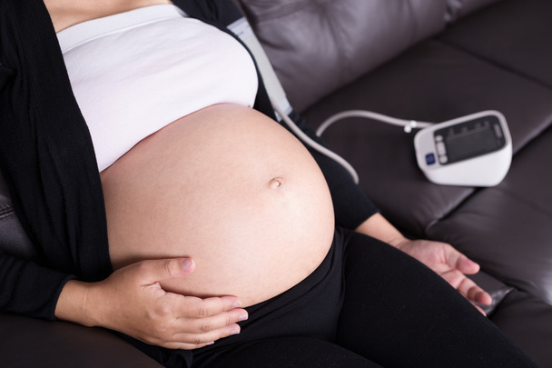 Pregnant woman measures blood pressure - 写真・画像