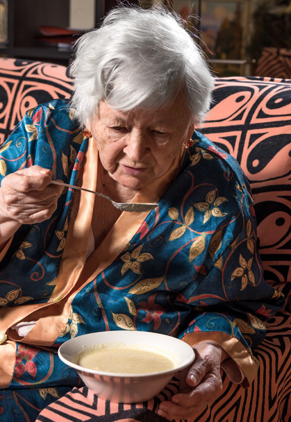 Стара жінка їсть суп
 - Фото, зображення