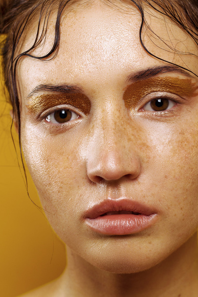 Portrait of a beautiful girl on a yellow background with the effect of wet skin - Foto, Bild