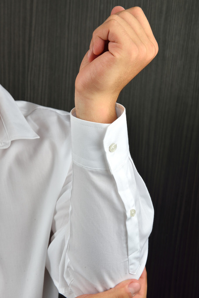 Крупним планом рука людини з закритими кнопками на білому рукаві шиї
 - Фото, зображення
