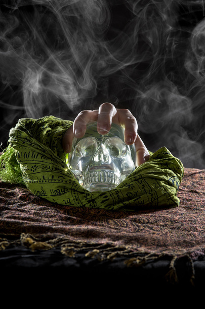 Hand grabbing crystal skull - Фото, изображение
