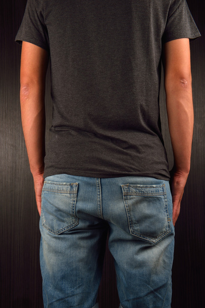 Back of young man wearing grey blank t-shirt, standing in a stud - Fotó, kép