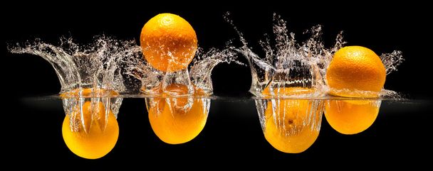 Group of fresh fruits falling in water with splash on black back - Фото, изображение