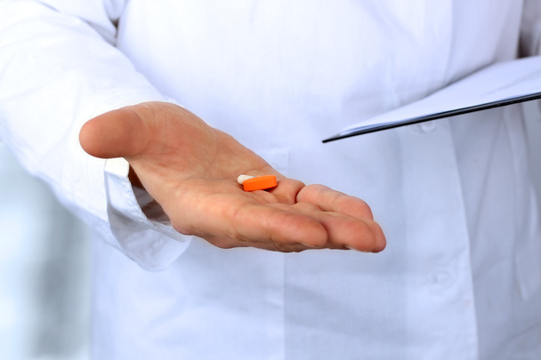 Γιατρός σε ένα λευκό labcoat δίνοντας χάπια - Φωτογραφία, εικόνα