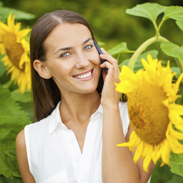 Close-up portrait of beautiful joyful woman with sunflower - Fotografie, Obrázek