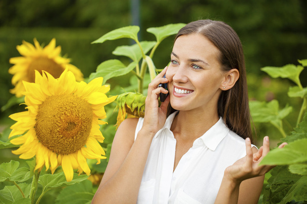 Close-up portrait of beautiful joyful woman with sunflower - Фото, зображення