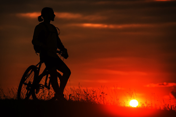 Gökyüzü arka plan günbatımı sırasında bisikletle silüeti - Fotoğraf, Görsel