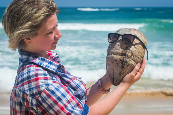 Chica sosteniendo un coco en la playa del océano tropical
. - Foto, Imagen