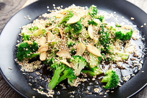 Steamed broccoli with garlic chips and sesame seeds - 写真・画像