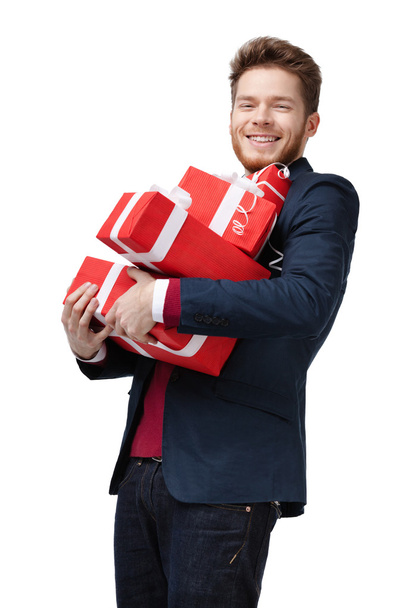 Young man carries a lot of presents - Foto, afbeelding